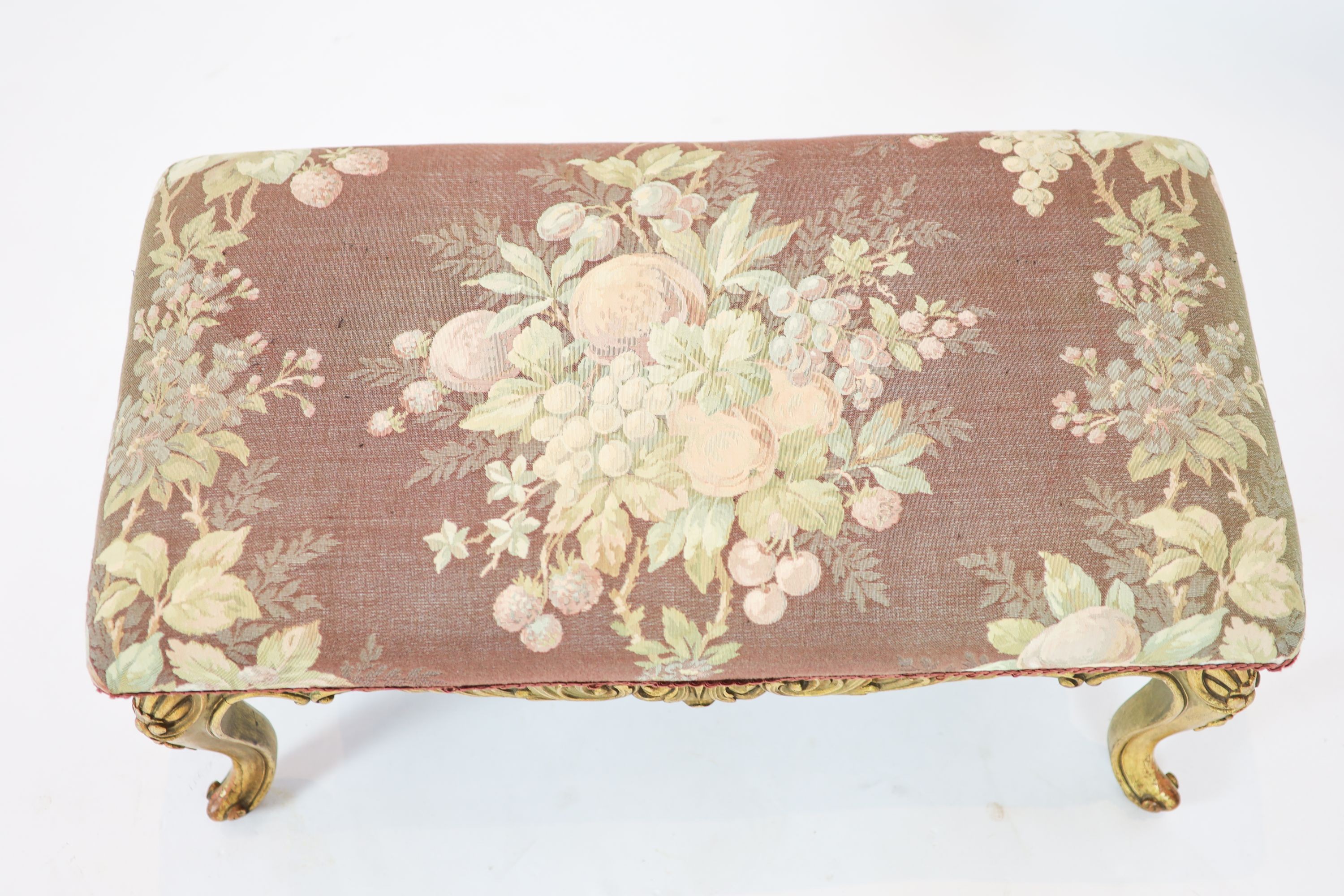 A Louis XV style carved giltwood dressing stool, with a pierced apron, on short cabriole legs, length 84cm, width 45cm, height 42cm
